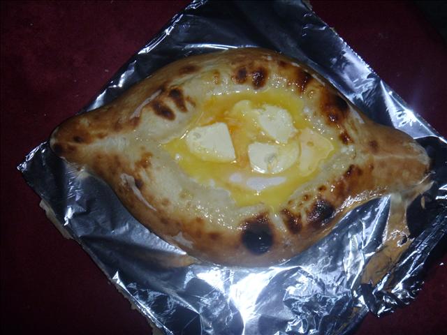Adjara Khachapouri topped with half raw egg and butter. It is so greasy it has to help great against hangover