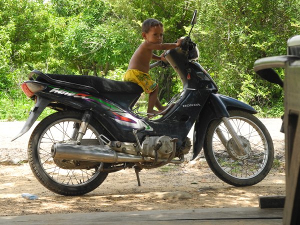 He was witing for his father. But his older siblings already drove their own motorbikes