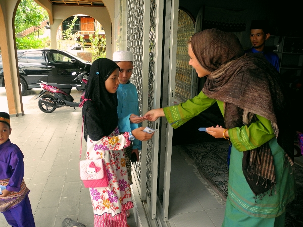 Giving out the money to the kids on Hari Raya