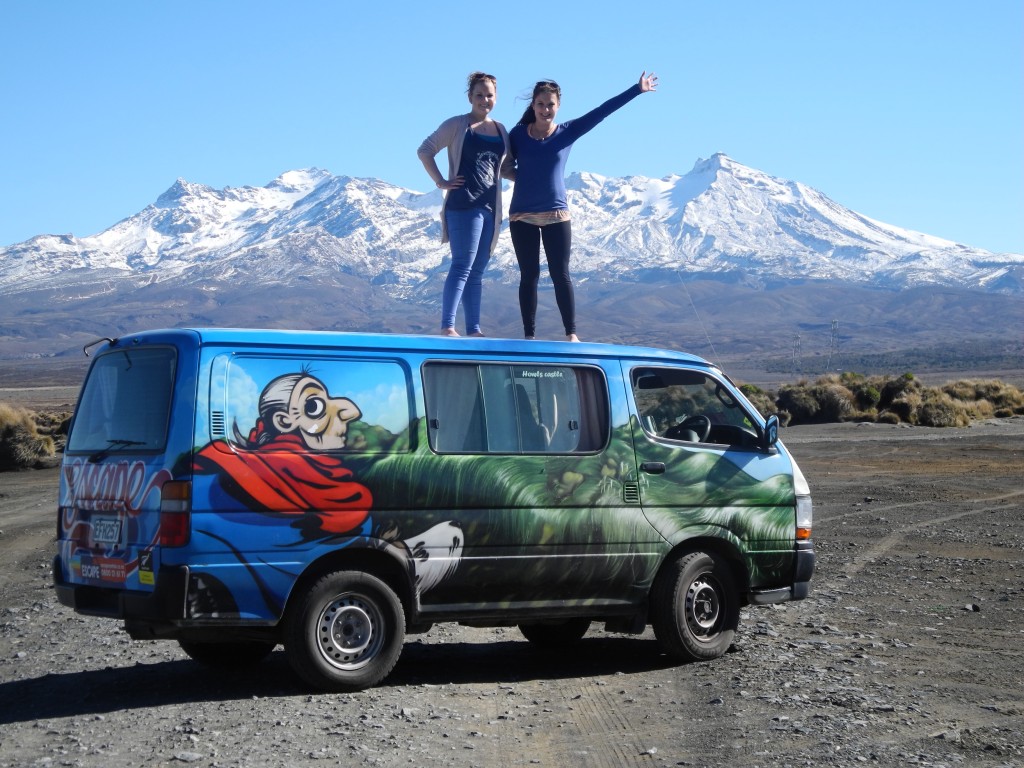 Two backpackers standing on their campervan in Tongariro National Park